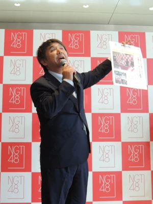 会見終了後、外で配っていた号外を手に会場のお客さんにお礼を言う今村支配人。