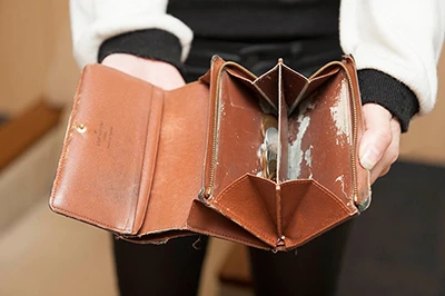 年季の入った財布。小銭入れの裏地は剥がれ、ボタンはバカになってフタはしまらない。ガビーン!