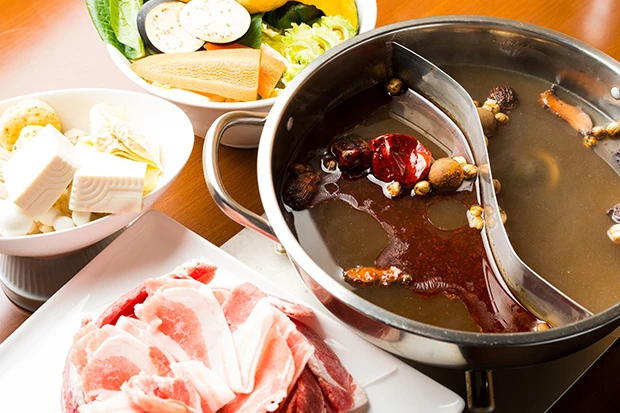 唐辛子や山椒など調味料がたくさん入った辛い味付けの麻辣(マーラー)スープで煮て食べる薬膳火鍋。うまみの中のヒリヒリする辛さが癖になる。