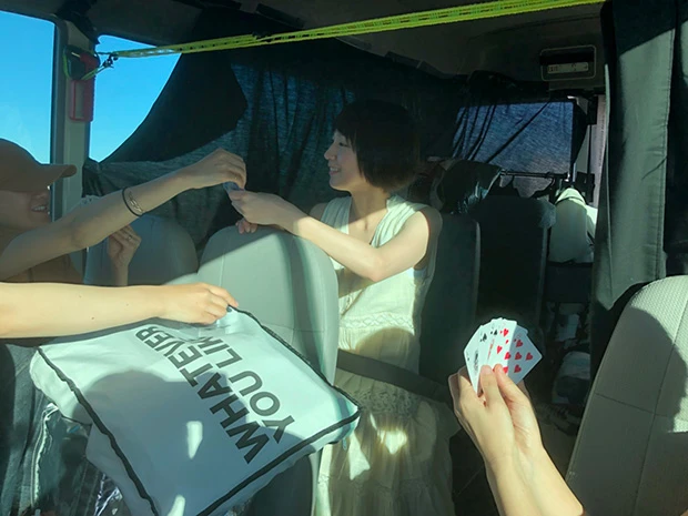  日本列島縦断に匹敵する２６００㎞の距離を一台のバスで走破する異例の写真集ロケを敢行した吉岡里帆。写真は道中の車内、スタッフとトランプに興じる様子
