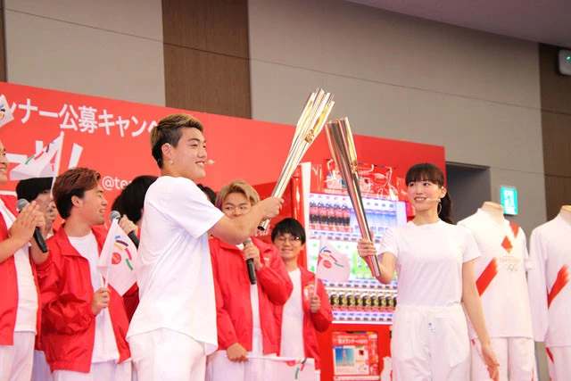 聖火を移すためトーチ同士を重ねる