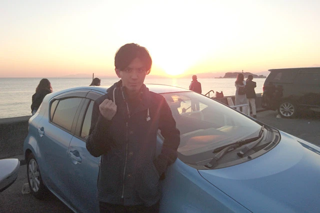 ライターが自力で運転し、男友達と鎌倉まで。駐車にはまだまだてこずったが、乗ってきた車と夕日を背にガッツポーズ！　もはや、運転の喜びに目覚めつつある