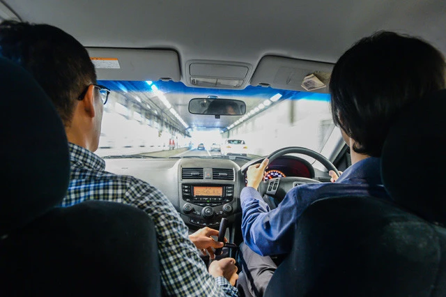 一般道とは大違いの、首都高ならではのスピード感が襲いかかってきた! 万一の事態に備え、河津さんは補助ブレーキを握り締めている