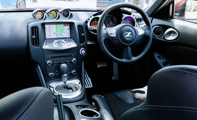 ダッシュボードの中央には左からデジタル時計、電圧計、油温計の3連メーターが鎮座する