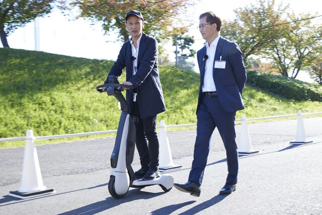 シーウォークティーを試乗しながら開発責任者のトヨタ自動車トヨタZEVファクトリーグループ長、谷中壮弘氏(右)に質問を浴びせる。ちなみに公道走行は不可