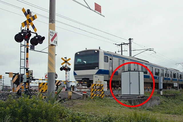 電車の運行、交通安全に重要な役割を果たすのが踏切だ。踏切には停電時などでも正常に動作するよう非常用電源が設置されている(写真の赤丸で囲った部分)