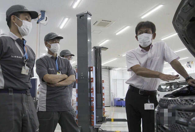 サクラの試作車を前に現場スタッフとディスカッションする永井氏(右)。気になる点は現場スタッフと徹底的に洗い出したという