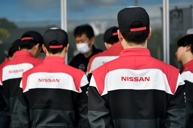「NISSAN」のロゴが刺繍されたつなぎを切る日産校の若きメカニックたち