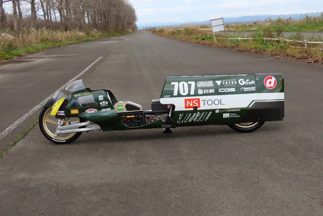 ボディデザインはモーターボート設計のスペシャリスト「カドエンジニアリング」に依頼。飛行機の翼の断面や水中を早く泳ぐ魚と同じ、長さと幅の比率（6：1）に。この比率が一番抵抗が少ないそう。そして「フューチャーズクラフト」の協力で、車体の素材をFRPからドライカーボンへ変更し、6kg以上の軽量化に成功した