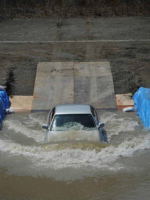 JAFによる冠水路での自動車走行テスト。水深60㎝の時速10キロのテスト。途中でエンジンが停止してしまった(画像提供/JAF)