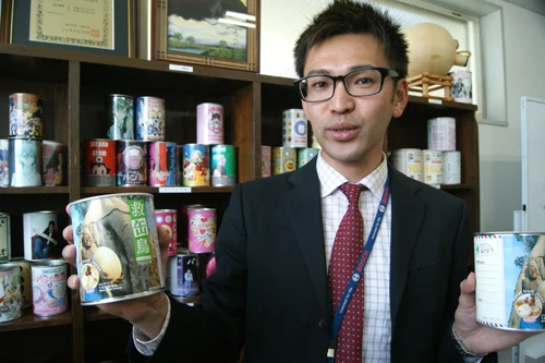 “救缶鳥”の缶(通常の倍の200グラム)を持つ秋元信彦部長