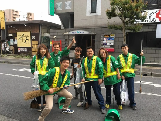 宇都宮駅付近で清掃活動を行なうアップライジングの社員。左下、ほうきをギターのように持っているのが斎藤社長