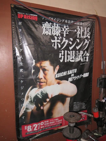 宇都宮本店の修理作業場に貼られていた、斎藤社長の“ボクシング引退試合”の特大ポスター。プロボクサーを引退したのは１０年以上前のことだが、「ボクシング人生にケジメをつけます」と、２０１５年８月に宇都宮本店の移転記念も兼ねて引退試合を開催した
