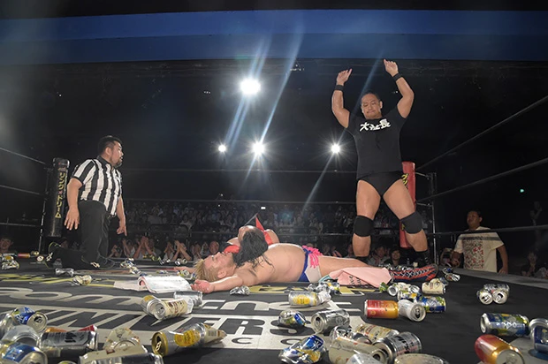 無数の空き缶が転がるリング上でダウンする男色ディーノ(中央)。異色のゲイレスラーにして、高いプロデュース力を持つ。