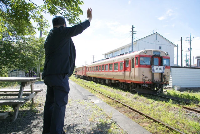 国吉駅を発車するキハ28とキハ52の急行を見送る鳥塚氏。先月、いすみ大使に就任し、今度もいすみ市の魅力を全国へ伝える役割を任された