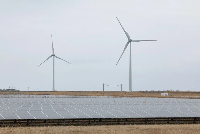 福島県南相馬市の海岸沿いに設置されているソーラーパネルと風車。日本は年間の総発電量における再エネ比率が2021年度に初めて2割を超えたが、4割を超えるヨーロッパの主要国に比べるとだいぶ低い水準だ