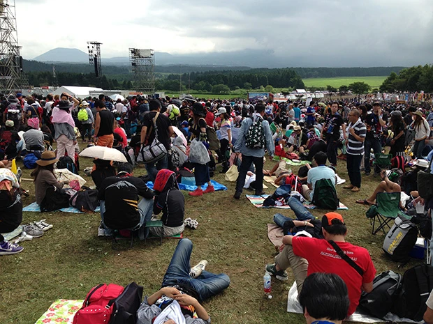 朝６時にライブが終わり、規制退場できるまで雑魚寝する観客達。日よけもなく暑かったが疲れが勝って爆睡！