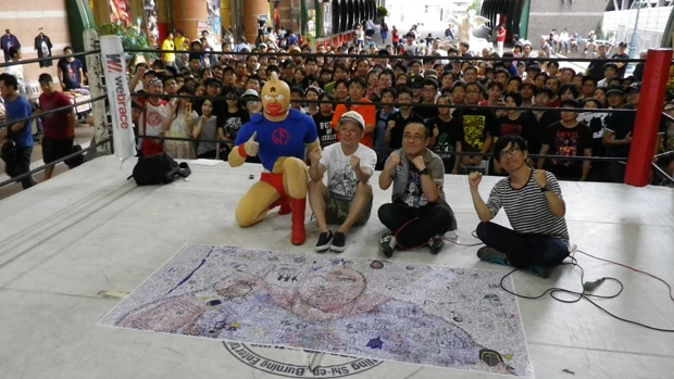 来場者が書いた寄せ書きを前に写真撮影