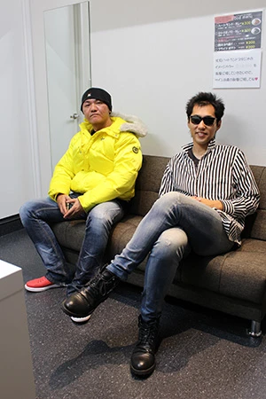 Takuya Nagabuchi(右)と応援団長の竹島さん(左)。「ストライプのシャツは『STAY DREAM』ツアーの衣装でEP盤『ろくなもんじゃねえ』のジャケットで剛さんが着てた衣装を意識してます」とTakuya。私服までこだわるマジっぷり!!