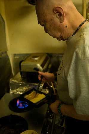 人気のメニューは「卵焼き」「ニラレバ炒め」など。店内にはライダーグッズがたくさん飾られている