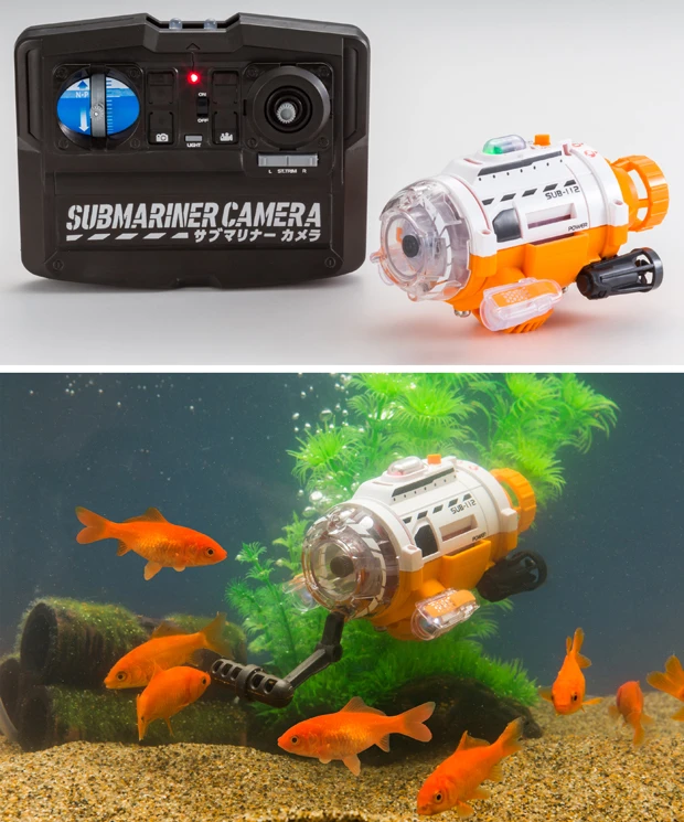 【左】全長約112mmの極小潜水艦にカメラを装備。潜水艦を水槽に入れて、ペットのお魚さんなどを撮影できる新感覚なドローン。本体メモリーは256MBで約800枚の画像、5分の動画を撮影が可能だ【右】撮影時は「エサ入れアーム」でお魚をおびき寄せ激写! ゲーム感覚で楽しめます