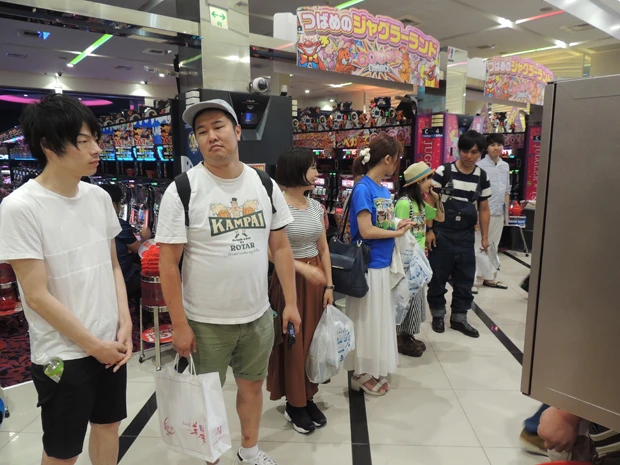  実践終了後、ホールで感想を述べる芸人、パチンコライターたち。たくさんの人が写真を撮っていた