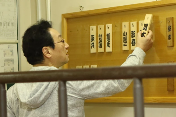 私服に着替え、楽屋の名札を裏返す師匠。そして次の落語会へ。超多忙な日が続く