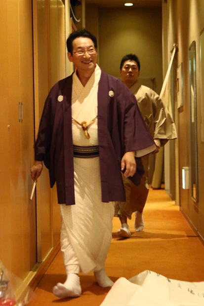 一席終えて楽屋に戻る師匠。爆笑と割れんばかりの拍手に送られ、笑みがこぼれていた