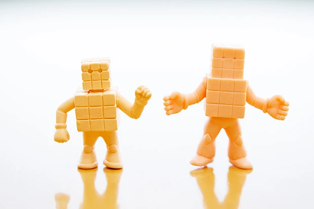 左が廣田氏のお父さんが原型つくっていた旧型の「キューブマン」。右は今回、廣田氏によって新規造形されたもの