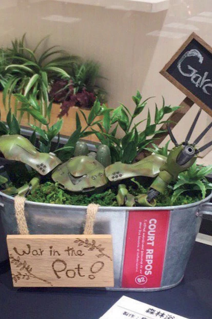  プランターの森に隠れるハイゴッグ。もともと水中用のモビルスーツで水色をしているが、「手を開くと針葉樹の葉っぱみたいだったので」（島津さん）という理由で緑に塗られ観葉モビルスーツに。タイトルは『森林浴』