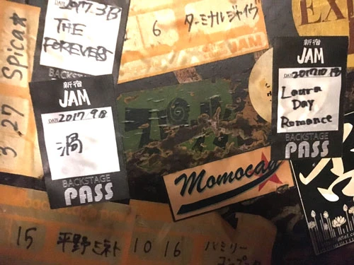 様々なバンドのステッカーに囲まれるスピッツのステッカー。古すぎて、もはや壁に同化している