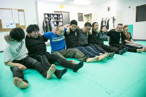 参加者全員で肩を組んでの腹筋。ペースを合わせられなければ、みんなの大迷惑。先生の表情にも焦りが!!