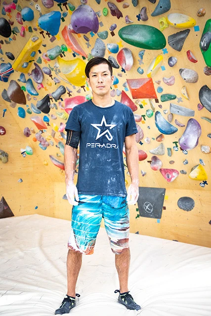 自身のブランド「PER-ADRA」(ペルアドラ)のクライミングシューズとTシャツを身に着けて。「現在生産している『K-01』に続く2モデル目も年内に試作品ができます。そちらは『日本人に合った』というコンセプトを踏襲しつつ、欧米人寄りの足にもフィットすることを目指したいなと。仕事柄最近、人の足をよく見るんですけど、日本人でも欧米人寄りの足をしている人もいますから」(川口)