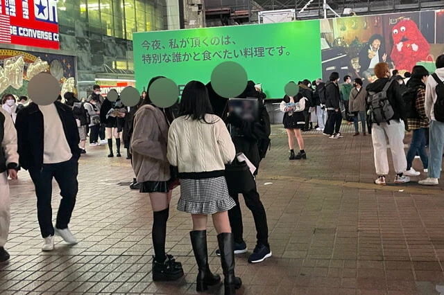 女性と話し込むメン地下。右奥には水色のビラを持つ地下アイドルの姿も