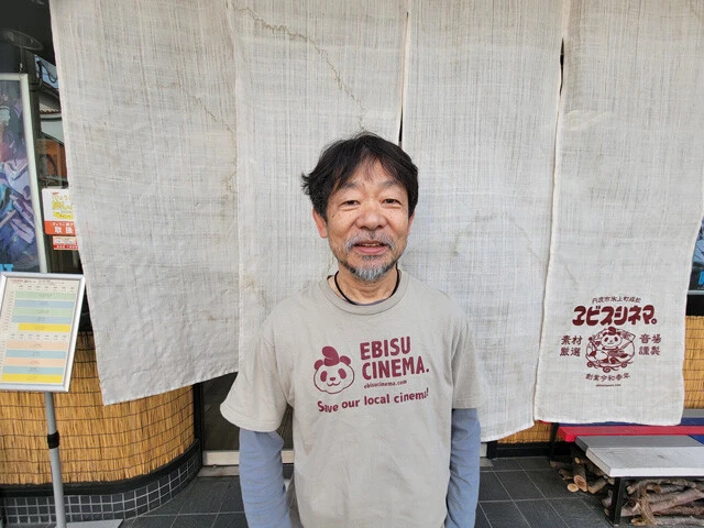 「ヱビスシネマ。」の支配人・近兼拓史氏（61歳）。映画監督、ライター、FIM＆AMAランドスピードレーサー、一般社団法人ジェネリック家電推進委員会の代表理事など、多才な顔と肩書を持つ