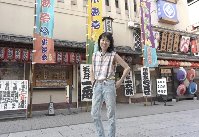 映像作家の川上アチカさん。日本唯一の浪曲の定席、浅草・木馬亭の前にて。毎月1～7日の昼間（12～16時頃）に浪曲を堪能できる。入場料は現在一律2400円（25歳以下半額）