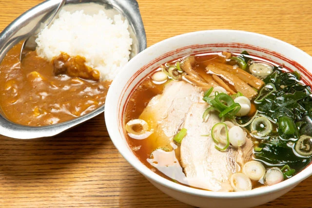 ラーメンの中細麺は、160gと通常より多め。甘みのあるスープにジューシーなチャーシューが合う。カレーはやや辛いが、コクがありクセになる味わい。男性客が多いため、ガッツリ食べられる「ラーメンと半カレーセット」が人気