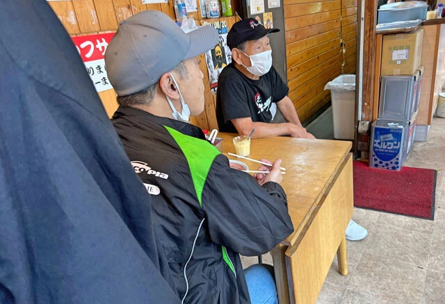 常連客と談笑する荒木さん。料理だけでなく、こうした交流があるからこそ地元で愛される店になっている