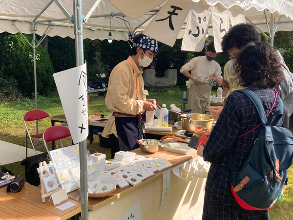 フライド絵画の露店に立つ永戸さん