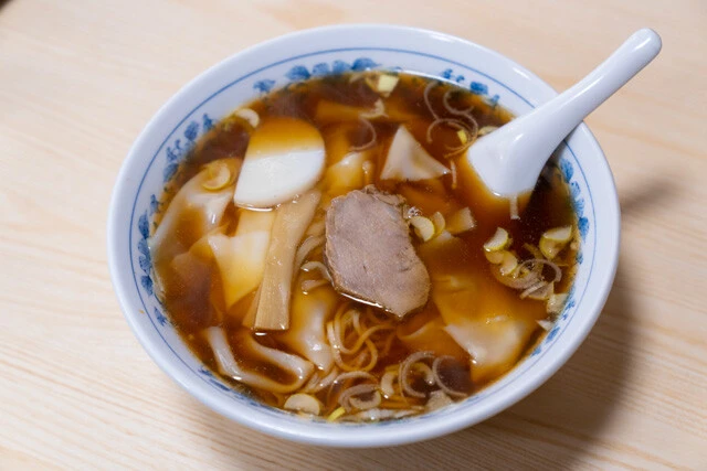 「ワンタンメン」（800円）は長きにわたり地元に愛され続けている名店の人気メニュー。つるんとした細麺と醤油ベースのキリッとしたスープ。そこに食感のよいワンタンと柔らかなチャーシューが加わる。何杯でもいける美味さだ。