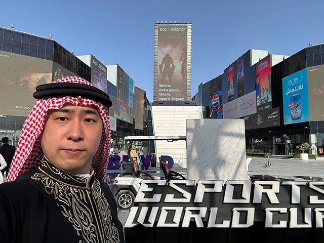 ＂中東で最も有名な日本人サラリーマン＂鷹鳥屋 明氏。後ろに映っているのはeスポーツW杯の会場となるブールバード・シティの正面入り口
