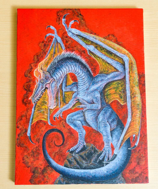 写真② 真っ赤な背景と、青みのかかったボディが特徴的なドラゴン。見たいドラゴン像を具現化するために、実在する恐竜の意匠を取り入れてリアリティを出した