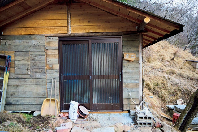 現在、手作りで建てている新しい山小屋。木で作られた表札に「東出」の文字。玄関にはシカのスカルホーンが置かれている