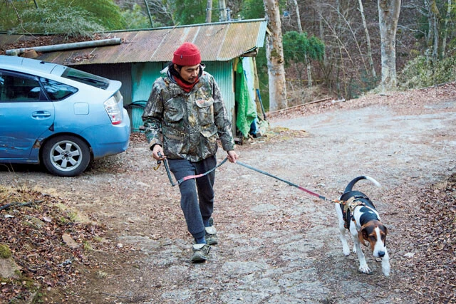 愛犬と散歩する東出。左に写っている車は東出の愛車だが、ボディは傷だらけ。過酷な山道を走ってきた証拠