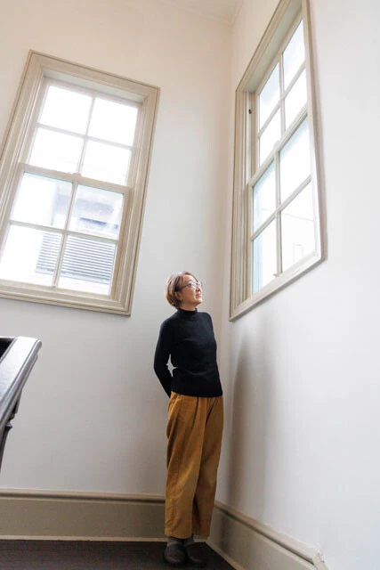 華やかな外観とは異なり、白を基調とした穏やかな内装。階段の踊り場にある波打つ窓ガラスは、奇跡的に割れずに残っていた当時のもの