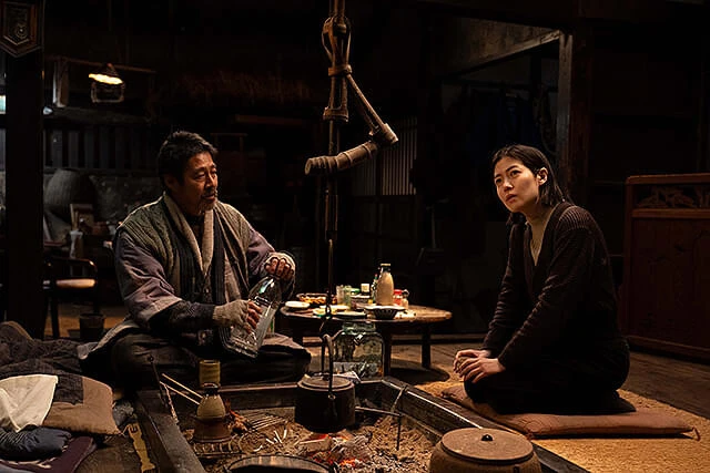 脚本家の李（右、シム・ウンギョン）は、べん造（左、堤真一）と出会い奇妙な交流を重ねるうち、自分自身と向き合っていく