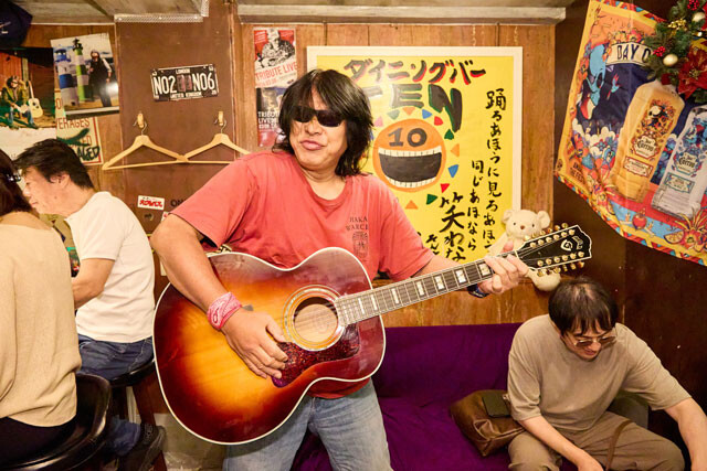 マイギターを手に歌い出す、常連さん。高校時代に衝撃を受け、以来、コンサート会場周辺でハマショーの弾き語りをしているという