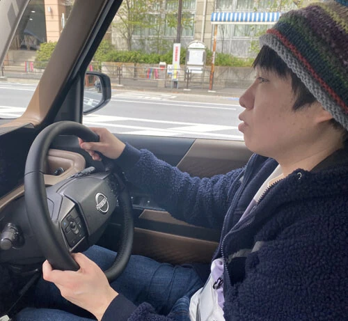 東京タワーを望むロケーションで、日産ルークスのステアリングを握る小田原先生