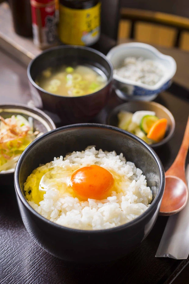 常時4、5種類の新鮮な卵が用意され、卵は食べ放題。さらにシラスや明太子、とろろなど8種類からひとつ選べるトッピングに味噌汁、漬物、小鉢がついてボリューム満点! 写真はオレンジの黄身が美しい「ゆうやけ卵」