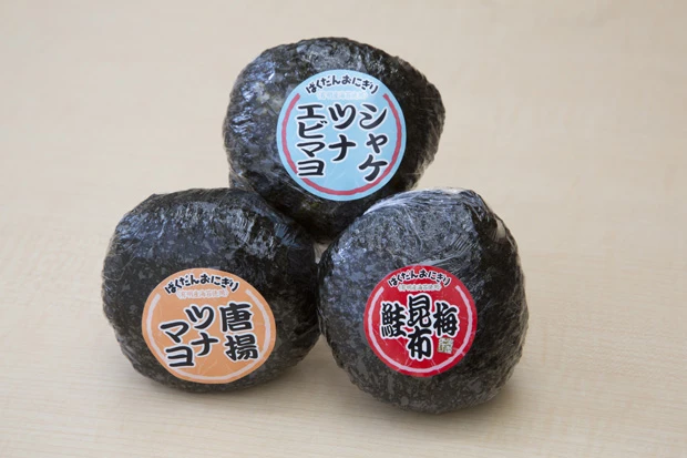  ひとつ食べれば満腹満足のばくだんおにぎり。具が２、３種類入っている。少しわかりづらいが、エビマヨおにぎりには小エビ一尾がまるまるイン！　価格は「シャケ、ツナ、エビマヨ」２００円。「唐揚、ツナマヨ」２００円。「梅、昆布、鮭」２０６円